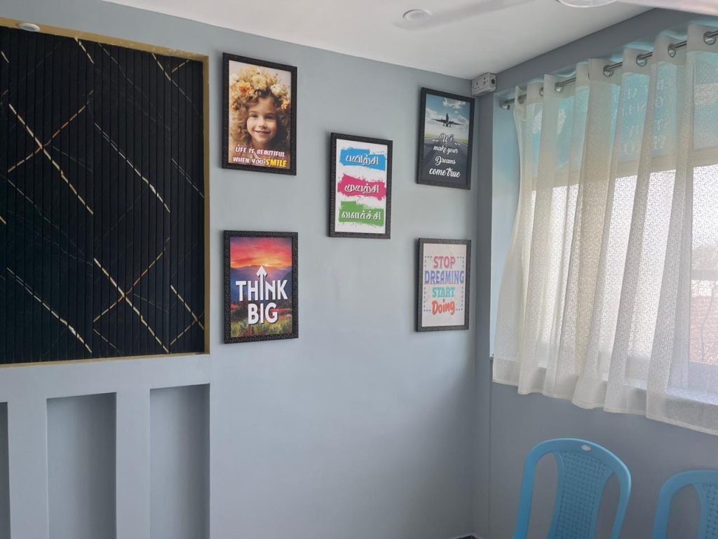 Interior office wall featuring framed art and a window with curtains.